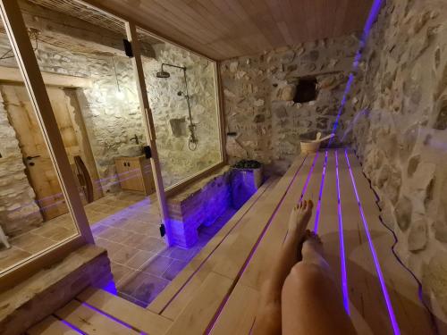 a persons feet on a bench in a room with a shower at Domaine de coulette in Vallon-Pont-dʼArc