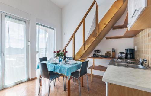 kuchnia ze stołem z krzesłami i schodami w obiekcie 1 Bedroom Gorgeous Apartment In Medulin w Medulinie