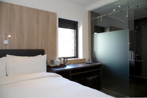 a bedroom with a bed and a glass shower at The Z Hotel Glasgow in Glasgow