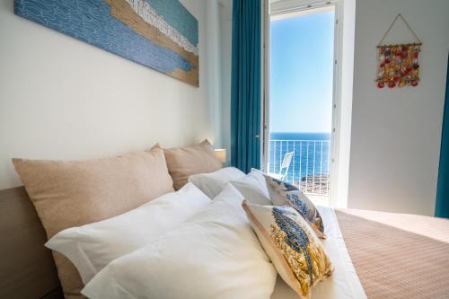 a bedroom with a bed with a view of the ocean at Donnamaria - Dimora Vista Mare in Polignano a Mare