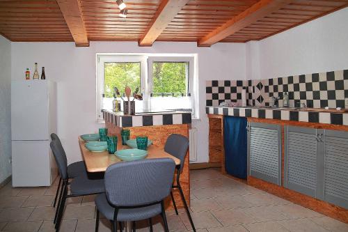 a kitchen with a table and chairs and a refrigerator at FeWo -schiefe- Marie in Oberlungwitz