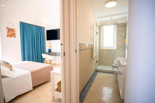 a hotel room with a bed and a bathroom at Donnamaria - Dimora Vista Mare in Polignano a Mare