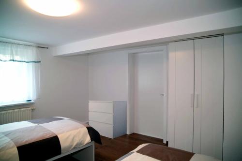 a bedroom with a bed and a cabinet and a window at FeWo -schiefe- Marie in Oberlungwitz