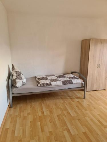 Cama en habitación con suelo de madera en TS1 2-OG Möbilierte Wohnung in Wolfsburgs Zentrum, en Wolfsburg