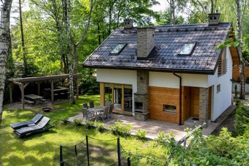 a cottage in the woods with a patio at Mazursko - domy in Kretowiny