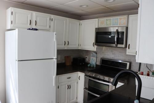 a kitchen with white cabinets and a microwave and a refrigerator at Sea View Motel in Ogunquit