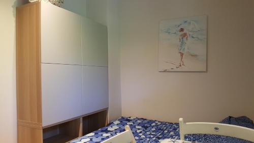 a small bedroom with a bed and a cabinet at Pestka in Jastarnia