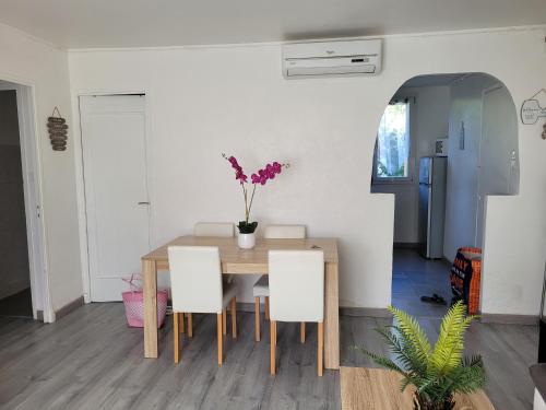 d'une table à manger avec des chaises et un vase de fleurs. dans l'établissement A 10 min des plages en voiture et du stade vélodrome, à Marseille