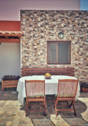 a table with two chairs and a stone wall at Casa en La Ladera - Real vibe - Beach & Mountain in La Aldea de San Nicolas