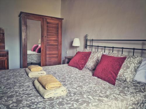 a bedroom with a bed with pillows and a mirror at Casa en La Ladera - Real vibe - Beach & Mountain in La Aldea de San Nicolas