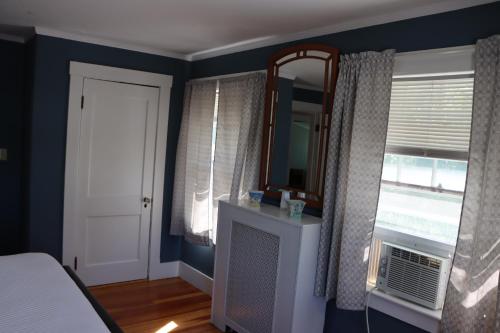 a bedroom with a bed and a mirror and a window at Sea View Motel in Ogunquit