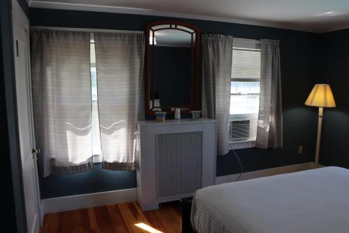 a bedroom with a bed and a window and a mirror at Sea View Motel in Ogunquit