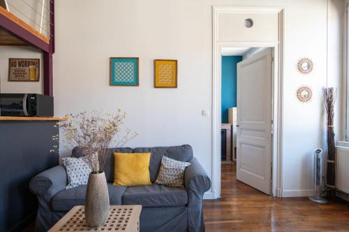 uma sala de estar com um sofá azul e uma mesa em L'Indigo- Coup de coeur Canut - Croix Rousse em Lyon