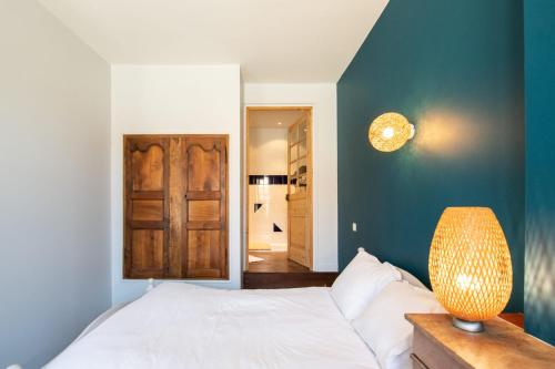 um quarto com uma cama branca e uma parede azul em L'Indigo- Coup de coeur Canut - Croix Rousse em Lyon