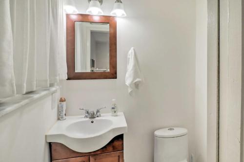 a white bathroom with a sink and a toilet at Norfork Getaway Walk in White River Access! in Norfork