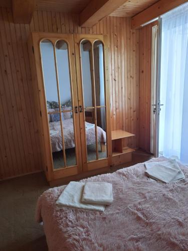 a bedroom with a large bed with glass windows at Ibis in Sovata