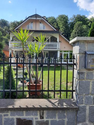 a fence in front of a house with palm trees at Ibis in Sovata