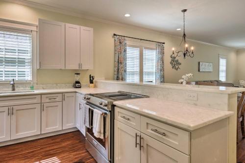 a kitchen with white cabinets and a stove top oven at Lovely Mobile Retreat with Deck and Front Porch! in Mobile