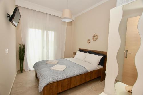 una camera da letto con un letto e una TV in una stanza di Lovely apartment by the sea..... a Epanomi