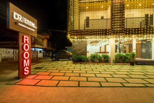 a sign in front of a building with lights at Daan Regency in Trichūr