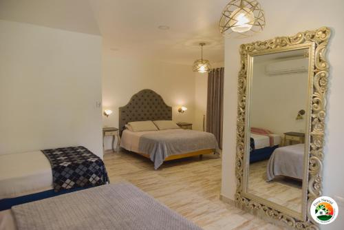 a hotel room with two beds and a mirror at Hotel Finca Naranjal in Granada