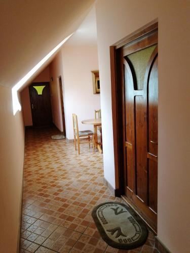 a hallway with a wooden door and a table at Fodor Vendégház in Racu
