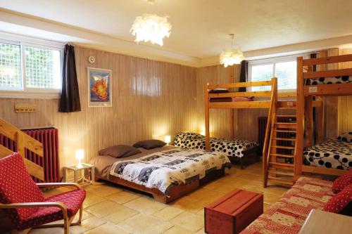 Gîte SOLDANELLE - 15 personnes - "Les Gites du Chalet" à Autrans في أوترانس: غرفة نوم مع سرير وسريرين بطابقين
