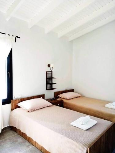 two beds in a room with white walls at Villa Narlibahce in Ortaca