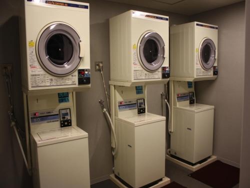 a room with three washers and dryers on a wall at Solaria Nishitetsu Hotel Kagoshima in Kagoshima
