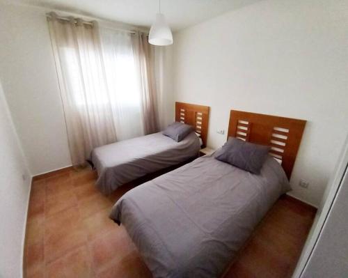 a bedroom with two beds and a window at Precioso Apartamento con vistas al Mar en La Alcaidesa in San Roque