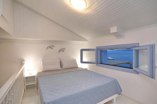 een slaapkamer met een bed en een raam bij Skopelos Aerino house in Skopelos Town