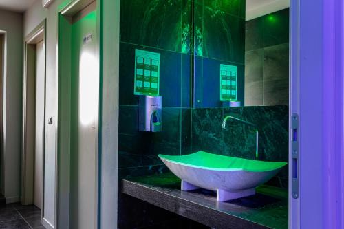 een badkamer met een bad en een groene bij Pasta Residence Italia Malpensa in Gallarate