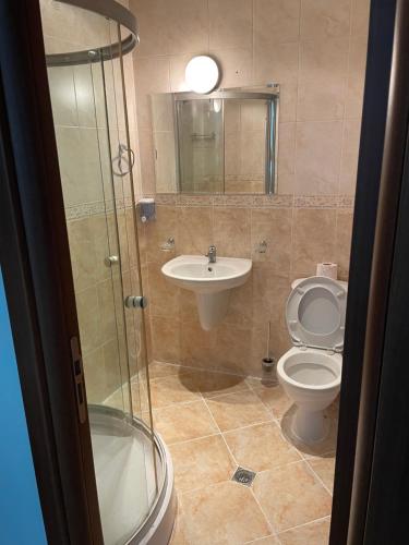 a bathroom with a toilet and a sink and a shower at Spacious and cozy Apartment in complex Del Sol in Primorsko