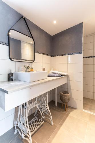 une salle de bain avec un lavabo blanc et un miroir dans l'établissement Domaine mon doux rêve, à Terrasson