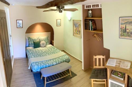a small bedroom with a bed and a chair at Lou Mistral in Moustiers-Sainte-Marie