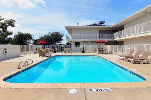 a swimming pool in front of a building at Motel 6-Corpus Christi, TX - Northwest in Corpus Christi
