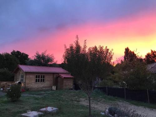 une maison dans une cour avec un ciel coloré dans l'établissement Chalet Boréal, à Pujaudran