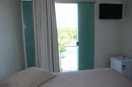 - une chambre avec un lit et une grande fenêtre dans l'établissement Hotel Grutta, à Bom Jesus da Lapa