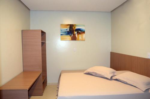 a bedroom with a bed and a wooden cabinet at Hotel Grutta in Bom Jesus da Lapa