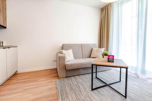 ein Wohnzimmer mit einem Sofa und einem Tisch in der Unterkunft VacationClub – Jantaris Apartament A8 in Mielno