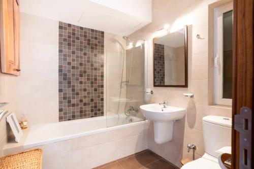 uma casa de banho com um lavatório, uma banheira e um WC. em Luxury Seafront 2 bedroom apartment in Spinola Bay em St. Julian's