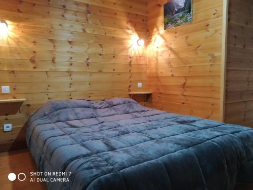 a bedroom with a bed in a wooden wall at Chalet les Alpes - Le Sapey in Vénosc