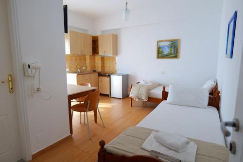 a bedroom with a bed and a kitchen with a table at Alex & Sofi Hotel in Himare