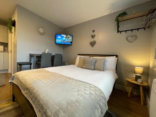 a bedroom with a bed and a tv on the wall at Westend Holiday Let 4 Brecon in Brecon