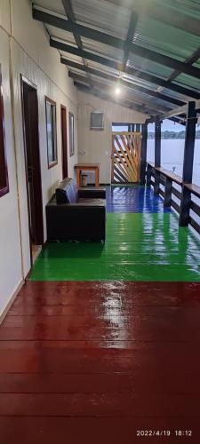 a living room with a green floor and a couch at EL DORADO POUSADA in Barcelos