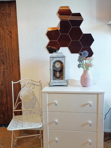 a dresser with a clock and a chair at Casale la Decima in Budrio
