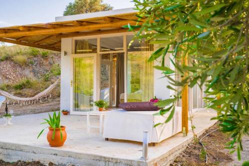 Panstel Bungalows in Kerames Rethymno في Kerames: منزل صغير مع شرفة مع أريكة