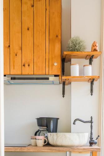 a kitchen counter with wooden cabinets and a sink at Panstel Bungalows in Kerames Rethymno in Kerames