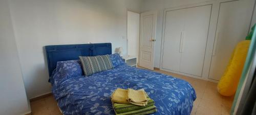 アロナにあるApartamento con Vistas al Mar en Los Cristianosのベッドルーム1室(ブルーベッド1台、タオル付)