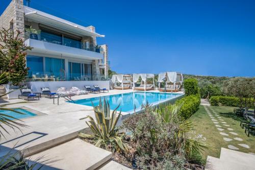 a villa with a swimming pool and chairs at Made of Blue luxury suites collection in Rethymno Town